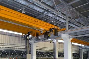 Overhead crane inside factory or warehouse building. Industrial machine or lifting equipment...