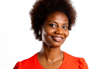 Young black woman, smiling and looking sideways at the camera on white background