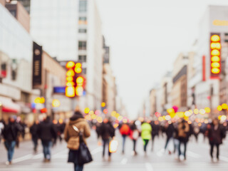 Obraz premium Blurred street scene with many people walking among tall buildings in a city.Premium urban photos for poster, banner and pamphlet backgrounds