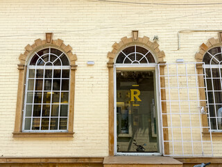 The building has a white facade with a yellow lettering that says R