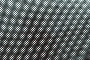 black fabric with small white dot pattern. Abstract dotted textile texture in monochrome tones....