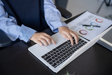 Asian businesswoman using laptop doing documents