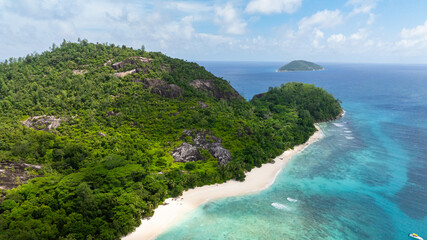 Aerial view of island with a sandy beach and tropical vegetation. Seychelles, Therese island.
