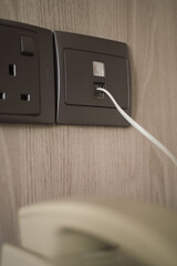 Charging device plugged into wall socket in modern setting