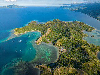 Tropical island surrounded azure water atoll and coral reefs. Sleeping Dinosaur Island. Mati, Davao Oriental. Philippines.