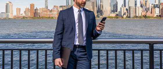 Business chat communication. Businessman using phone. Chatting and texting SMS on Manhattan...