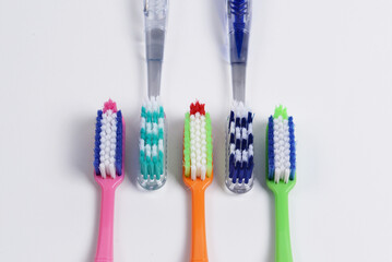 A variety of colorful toothbrushes with soft bristles, used for cleaning teeth, gums, and tongues. Soft bristles are recommended to protect enamel and sensitive gums.