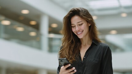 Happy woman enjoying her smartphone in a modern indoor environment.