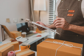 an employee is packing products into boxes to prepare for shipping to customers, a small online business owner is checking boxes for accuracy before shipping to customers, parcel,