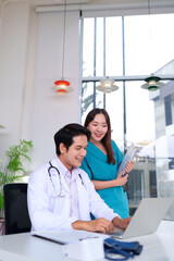 Asian Doctor and Nurse Teamwork on Laptop Computer Medical Report Analysis Healthcare Professional Adult Staff at Clinic or Hospital for Patient Care