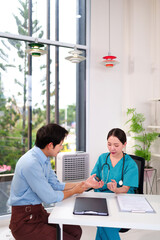 Asian Female Doctor Examining Adult Male Patient Hands and Wrist in Clinic Office for Medical Consultation and Healthcare Treatment