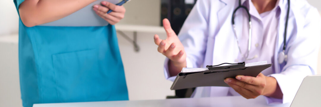 Adult Doctors Discussing Medical Records and Patient Care in Hospital Setting Healthcare Professionals Collaboration and Examination for Health Improvement - Powered by Adobe