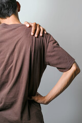 Portrait of a man suffering shoulder pain isolated over a white background. Concept of healthcare