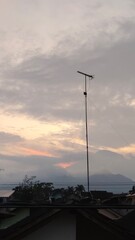 scenery of the gray sky with the roofs of houses and antenna