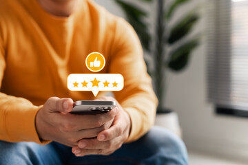 Customer feedback on digital satisfaction, young man uses smartphone to leave 5-star rating and...