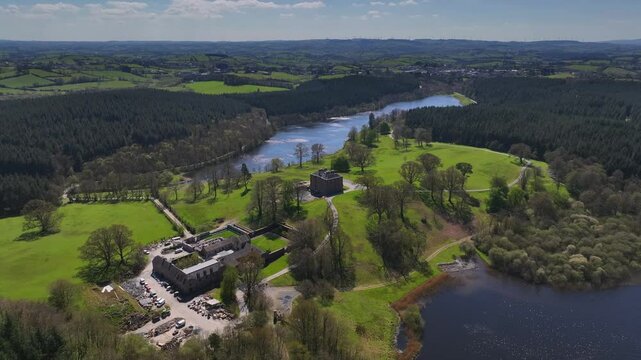 Bellamont House, County Cavan, Ireland, April 2023. Drone orbits clockwise over historic estate, trees and countryside, scenic aerial view with vibrant natural beauty.