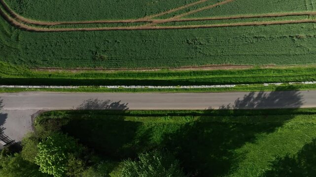 Caledon Border Wall, County Tyrone, Northern Ireland, May 2023. Drone birdseye view moves right above border wall and lush farmland scenic aerial view on sunny day.
