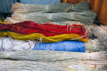 dry dyed reeds lie in piles at warehouse for production of traditional woven mats in a Vietnamese village in Vietnam