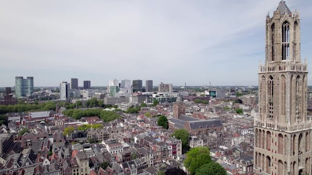 Closeup aerial view of cathedral De Dom church tower architecture of the Utrecht diocese with high rise modern contemporary buildings in the background