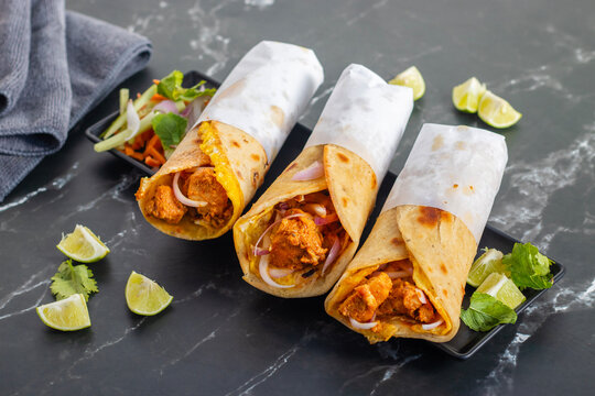 Egg chicken roll is a popular street food made with a flaky paratha, spiced chicken, egg layer, onions, and sauces, wrapped and served hot.
