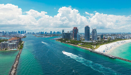 Fototapeta premium Aerial view of Miami Beach with turquoise waters. Drone shot of Miami skyline. Top view of South Beach. Miami cityscape with luxury skyscrapers and ocean. View of Miami famous coastline.