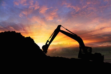 Crawler excavators silhouette are digging the soil in the construction site. on  sunset background