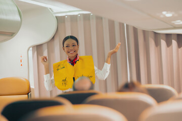 The flight attendant on the plane demonstrates the safety rules on the plane in a professional...