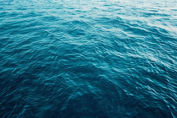 Gentle ocean waves gracefully rolling on a serene deep blue water surface, creating tranquility.