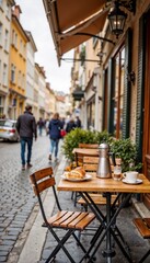 Fototapeta premium Outdoor cafe table with coffee and croissant on cobblestone street 