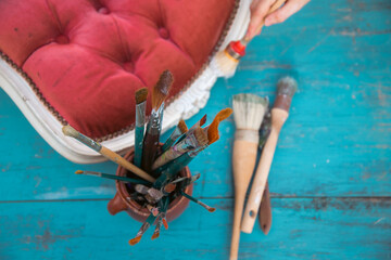 Painting a wooden furniture outdoors, an eco-friendly re-use business.