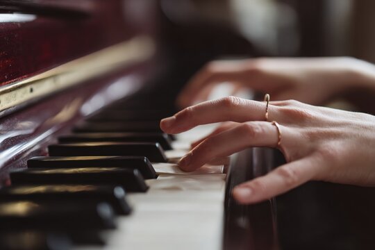 Favorite classical music...Close up view of gentle female hands playing a melody on piano while taking piano lessons. High quality