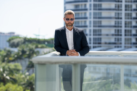 Business man standing confidently. Successful business man . Executive in suit. Handsome business man looking confident. Middle Eastern business man in urban setting. Mature businessman near office.
