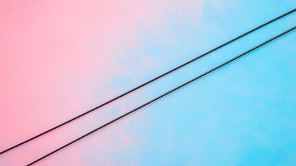 Fototapeta premium Two black cables run diagonally across a textured background split between pink and blue colors.