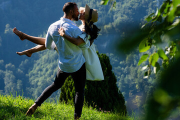 Summer vacation in nature. Couple enjoyed playful fun outside. Sexy couple hugged in nature. Sensual couple in love outdoors. The romantic couple in love shared a kiss on the sun-kissed meadow.