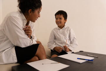 Child psychologist listening to young boy during therapy session