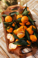 Ripe tangerines on the background of a wooden table. Assembled juicy tangerine in close-up. Delicious citrus fruits for juicing