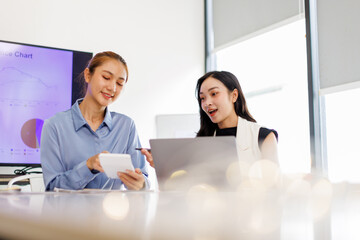 Business asian woman Reviewing Documents, business woman's hands meticulously reviewing a stack of...
