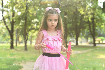 Happy girl playing with soap bubbles