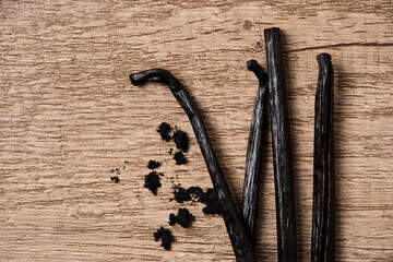 top view flat lay vanilla bean stick and seed on wooden table background with copy space