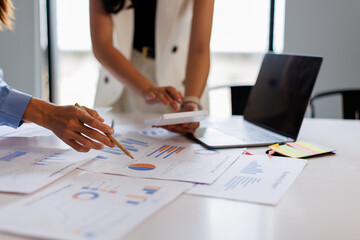 Financial analysts analyze business financial reports on a digital tablet planning investment project during a discussion at a meeting of corporate showing the results of their successful teamwork.	
