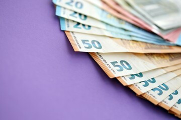 Big amount of european euro currency money notes on purple color table close up