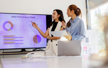 Asian Group of confident business discussing financial charts and graphs showing market growth...
