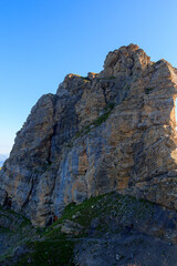 Rock face with small wooden entrance to fixed bivouacs in the mountains in Swiss Alps, Switzerland