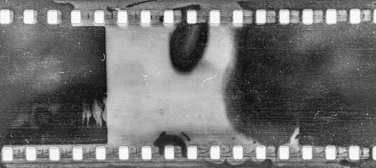 Damaged vintage 35mm film strip with visible scratches and burnt edges in black and white