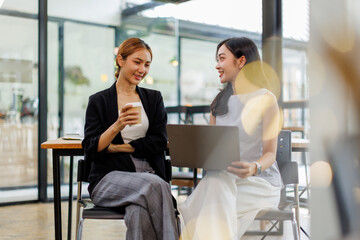 Obraz premium Two Asian woman entrepreneur busy with laptop computer her work in the office.Asian business casual concept. 