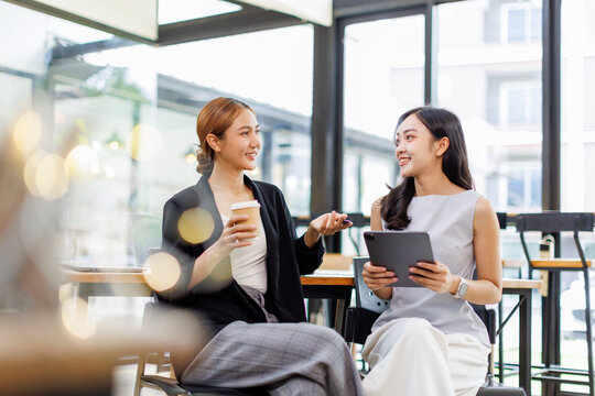 Two Asian business woman, women with a tablet laptop computer and documents. Freelance and selfemployment concept
- Powered by Adobe