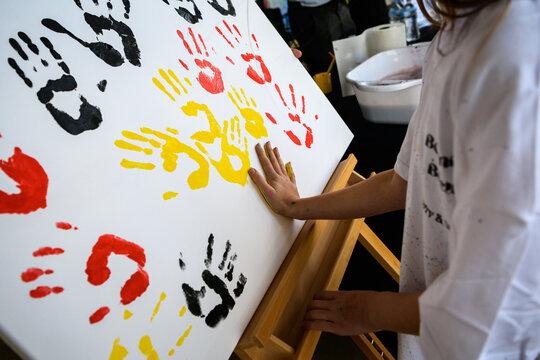 Hand prints made with paint in indigenous colours of black, red and yellow - horizontal