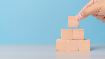 Hand placing empty blocks in a row. Concept of planning, process, or sequence setup.