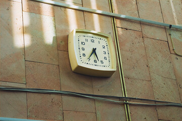 An old working clock hangs on the wall in a production room