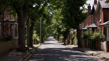 Fototapeta premium Quiet residential street lined with leafy trees and charming brick houses bathed in warm afternoon sunlight with ample copy space on the right